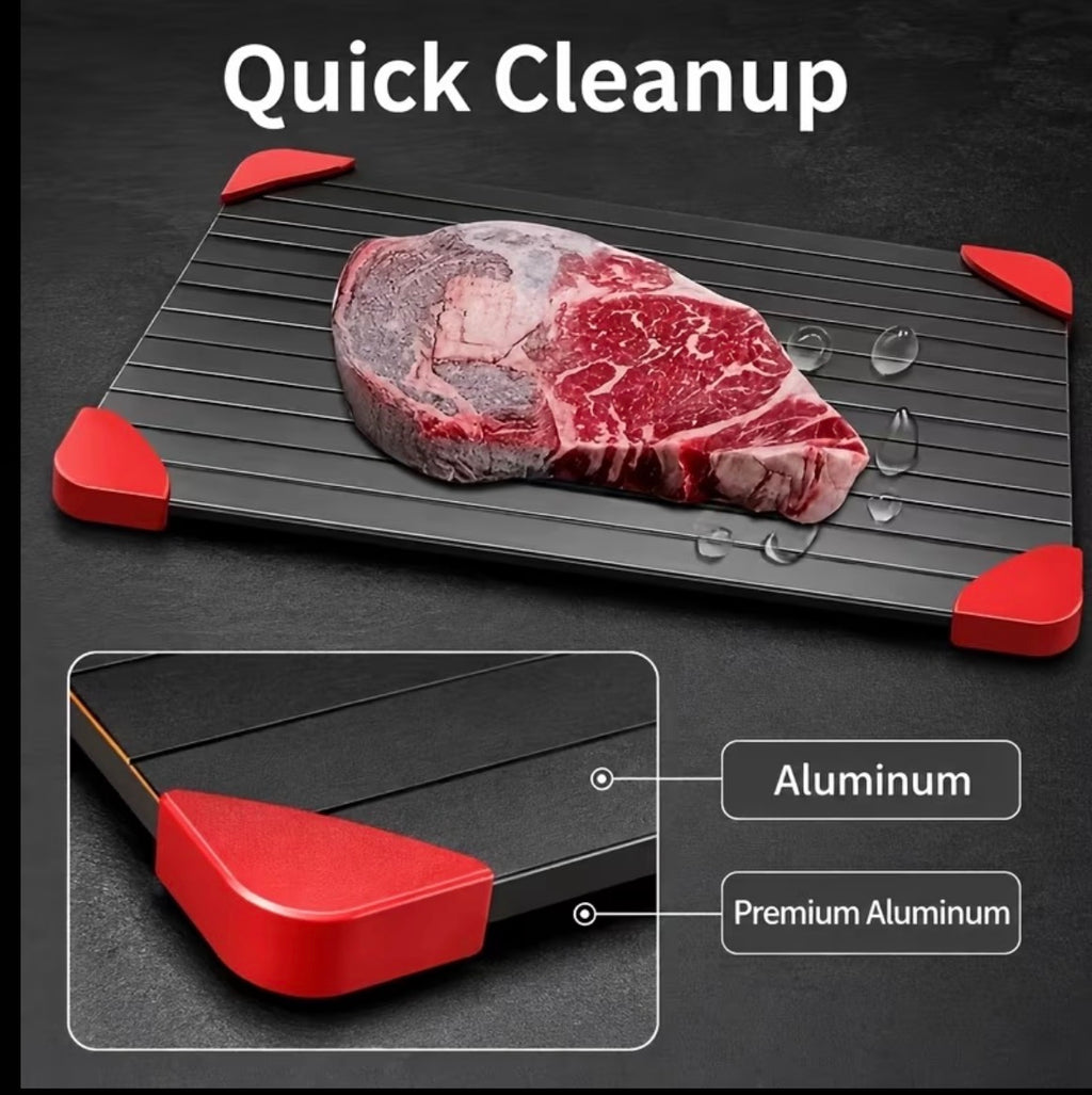 Black aluminum grill tray with red corner grips and steak