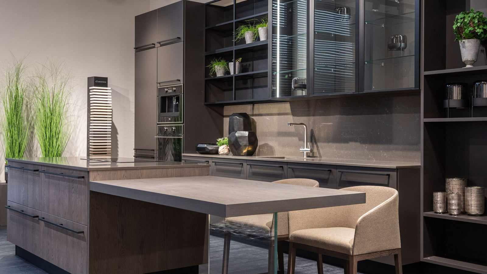 A modern dark kitchen with an island and warm lighting